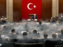 Turkish parliament session with lawmakers in discussion.