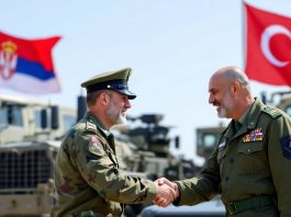 Serbian and Turkish military officers shaking hands.