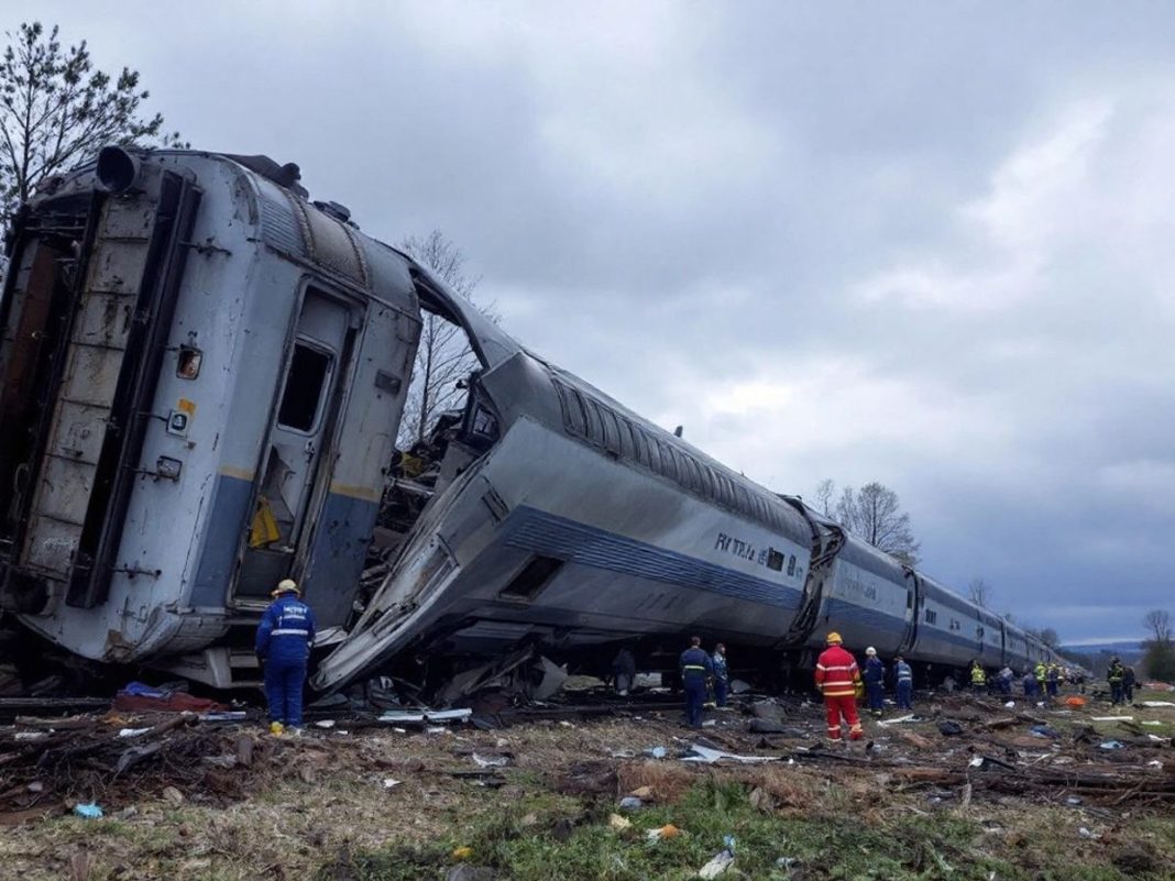 Train wreckage with emergency responders at the scene.