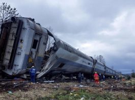 Train wreckage with emergency responders at the scene.