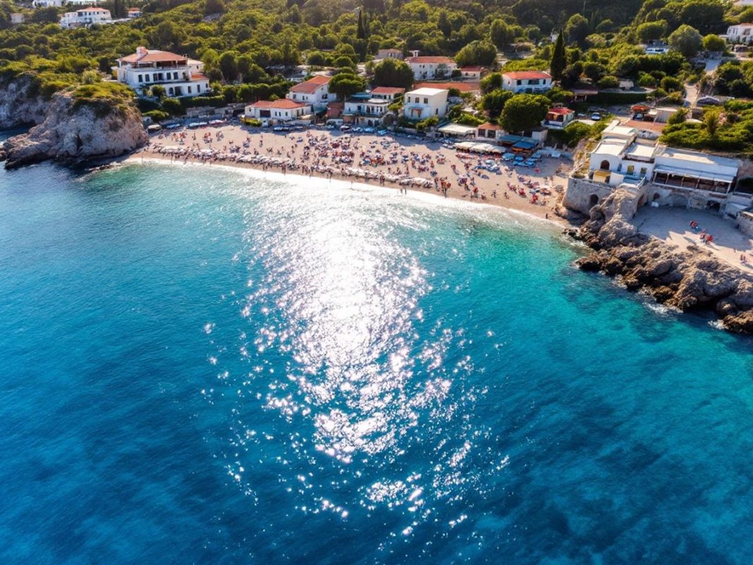 Beautiful Greek beach with clear waters and greenery.