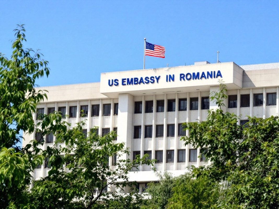 US Embassy building in Romania with flag and greenery.