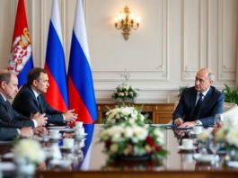 Serbia and Russia flags in a formal meeting setting.