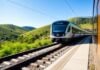 Train on upgraded railway track with scenic hills.