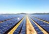 Vast solar farm under a sunny sky.