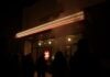 Nightclub fire aftermath with distressed crowd and emergency lights.